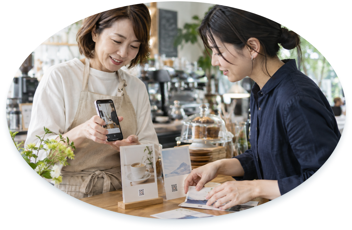 カフェでスマートフォンと印刷物を使った発信方法を相談するイメージ